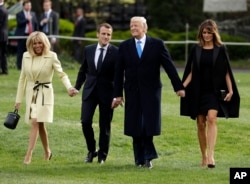 President Donald Trump and first lady Melania Trump walk on the South Lawn with French President Emmanuel Macron and his wife Brigitte Macron at the White House, April 23, 2018, in Washington.