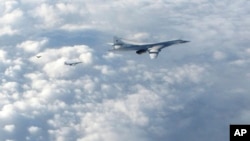 FILE - In this image made available by the Royal Air Force, Jan. 15, 2018, two Russian Blackjack Tupolev Tu-160 long-range bombers are followed by an RAF Typhoon aircraft (L) scrambled from RAF Lossiemouth, Scotland.