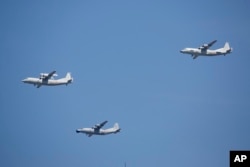 A KJ-200 airborne early warning and control plane, left, a Y-8J radar plane, center, and a Y-9JB radar plane, right, fly in formation during a parade commemorating the 70th anniversary of Japan's surrender during World War II in Beijing, Sept. 3, 2015.