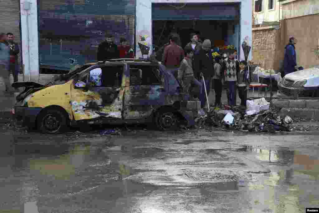 Residents inspect the damage caused by Islamic State in Iraq and the Levant suicide bombers at the Tawhid Brigade and Al-Fateh brigade headquarters in Aleppo, Jan. 12, 2014. 