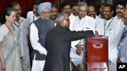 Pranab Mukherjee casts his vote in India's presidential election as PM Singh and Congress party president Sonia Gandhi, along with other lawmakers look on in New Delhi, July 19, 2012. 