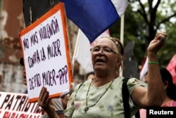 Women from different social, rural and urban organizations march to commemorate International Day for the Elimination of Violence Against Women, in Asuncion, Paraguay, Nov. 25, 2015. The sign reads "Stop Violence Against Women."