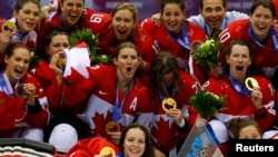 Team Canada players pose with their gold medals during the presentation ceremony after Canada defeated Team USA in overtime in the women's ice hockey final game at the 2014 Sochi Winter Olympics, Feb. 20, 2014.