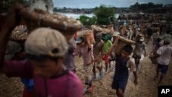 Trẻ em khiêng đá tại một bến cảng ở Yangon, Miến Ðiện. Các em kiếm được 3.000 Myanmar Kyat (khoảng 3,5 đô la Mỹ) sau khi bốc dỡ 300 rổ đá lên tàu.