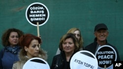 Greek and Turkish Cypriots holds banners reading in Greek, Turkish and English "Solution Now" in the divided capital Nicosia, Cyprus, April 2, 2017.