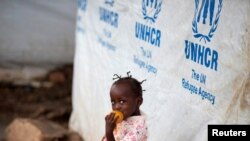 FILE - A girl eats a mango at a shelter for displaced people in Bangui, Central African Republic, April 24, 2017. 