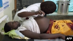 An employee at the Health Care center IV of Busiu in Mbale district, eastern Uganda attends to Mary Watera, who is pregnant with her first baby, September 27, 2011.