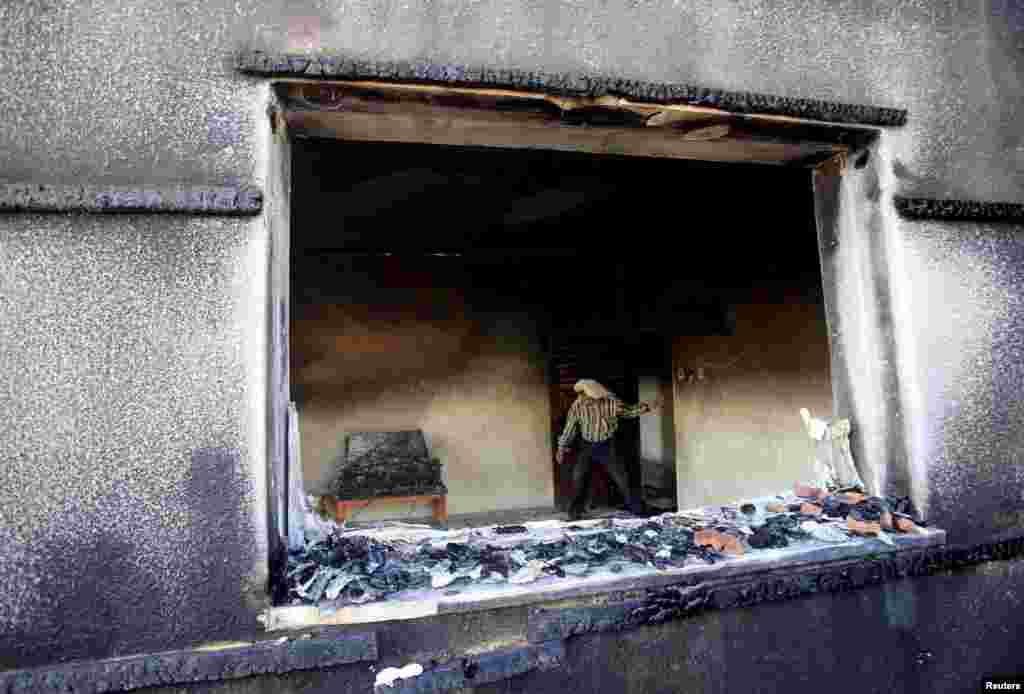 A Palestinian man inspects a house that was badly damaged in a suspected attack by Jewish extremists on two houses at Duma village near the West Bank city of Nablus. The fire in the Palestinian home killed an 18-month-old baby and seriously injured several other family members, an act that Israel&#39;s prime minister described as terrorism.