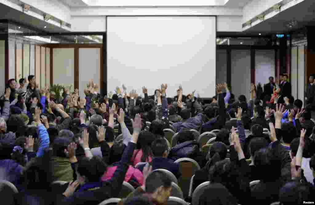 Family members of passengers onboard Malaysia Airlines Flight MH370 vote to talk directly to Malaysian government's representatives during a meeting with the airline's representatives at Lido Hotel in Beijing March 17, 2014.