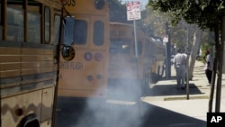 Buses spew diesel-fuel exhaust as they start up and pull away from an elementary school near Los Angeles, September. 6, 2000.
