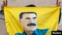 FILE - A Kurdish demonstrator holds a flag with a portrait of jailed Kurdistan Workers Party (PKK) leader Abdullah Ocalan in Strasbourg, France, Feb.14, 2009.