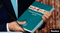 U.S. Secretary of State John Kerry holds a copy of the 2016 Trafficking in Persons (TIP) report during the TIP Heroes Ceremony at the State Department in Washington, June 30, 2016. 