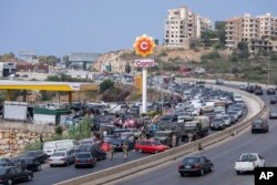 Cars come from every direction to fill their tanks with gasoline at a petrol station on the main highway in the coastal town of Jiyeh, south of Beirut, Lebanon, Sept. 3, 2021.