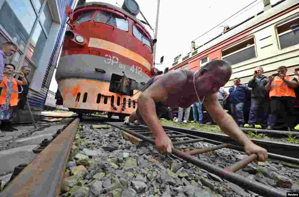 Athlete and powerlifter Ivan Savkin pulls a train with several carriages, weighing 120 tons in total, in the Russian far eastern city of Vladivosotk.