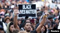 A protester raises his arms at a rally against police violence in Washington, D.C., Dec. 13, 2014.