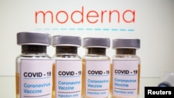 Botol vaksin Covid-19 dan jarum suntik medis terlihat di depan logo Moderna yang ditampilkan dalam ilustrasi yang diambil pada 31 Oktober 2020. (Foto: REUTERS/Dado Ruvic)