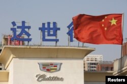 China's national flag flutters at Cadillac's dealership in Beijing, China, March 14, 2016.