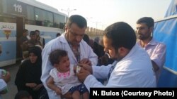 Medics at this collection point for fleeing families treat a baby for malnutrition, which they say is widespread among children in Mosul, Iraq, on July 12, 2017.