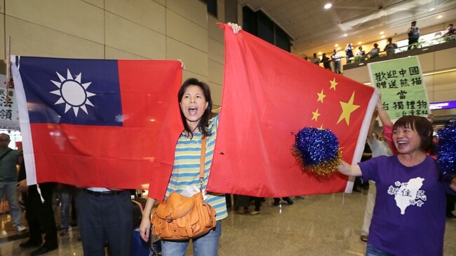 亲中国的台湾活动人士在桃园机场手举中国和台湾旗帜欢迎大陆海协会会长张志军访问台湾。(2014年6月25日)