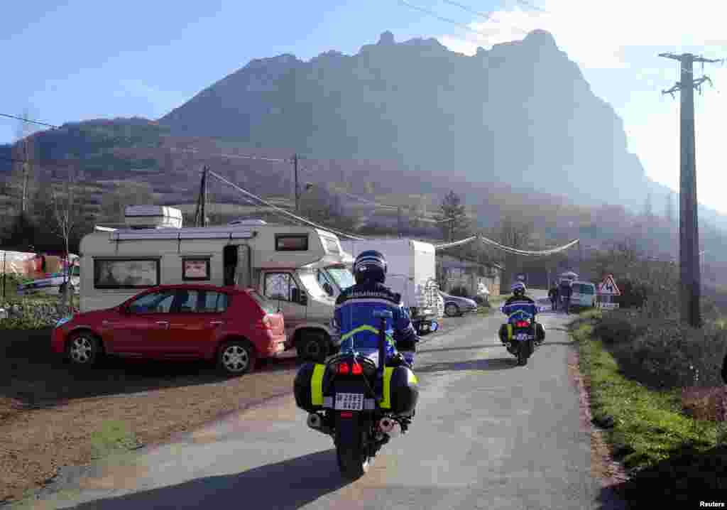 French Gendarmes patrol a street where mobile-homes are parked, on December 20, 2012, in the French southwestern village of Bugarach.