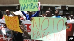 A group of protestors carry placards while demonstrating against the introduction of bond notes in Harare, Nov, 30, 2016.