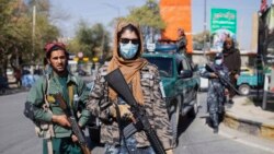 FILE - Taliban fighters stand guard during a protest by women in Kabul, Afghanistan, Oct. 21, 2021.