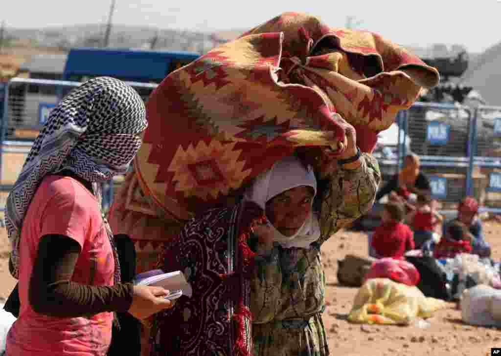 Syrian refugees from Kobani arrive at the Turkey-Syria border crossing of Yumurtalik near Suruc, Turkey, Oct. 1, 2014. 