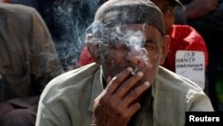 Hussain Jamal, a fisherman from India, smokes a cigarette as he sits with others, after their release from prison in Karachi, Pakistan, December 25, 2016. 