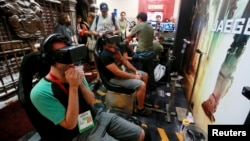 Attendees wearing Oculus Rift virtual reality headsets view a 3-dimensional video for the "Pacific Rim: Jaeger Pilot" video game during the 2014 Comic-Con International Convention in San Diego, California, July 25, 2014.
