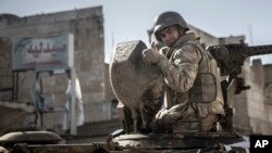 FILE - A soldier gives a thumbs-up sign as Turkish army's armored vehicles and tanks roll into the Syrian town of Ayn al-Arab, Feb. 22, 2015.