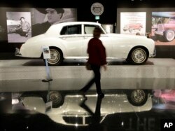 A woman walks past one of Elvis Presley's cars displayed at the "Elvis Presley's Memphis" complex in Memphis, Tennessee, March 2, 2017.