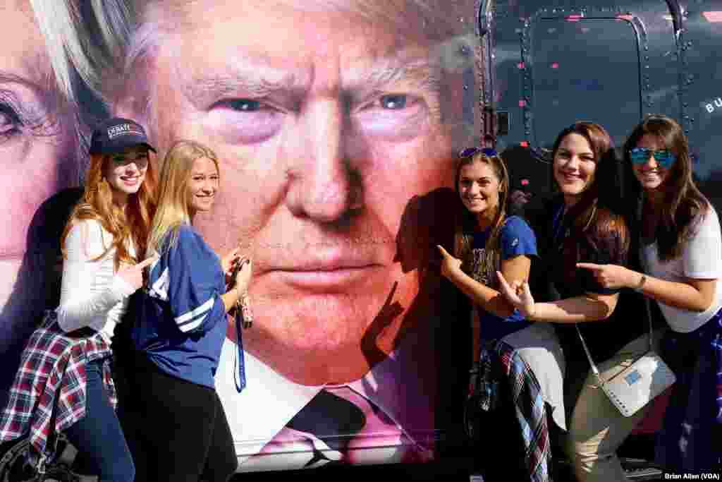 Hofstra University students pose with Donald Trump's likeness on the side of a bus. Trump will take on Hillary Clinton in an on-campus debate on Monday night. (B. Allen/VOA)