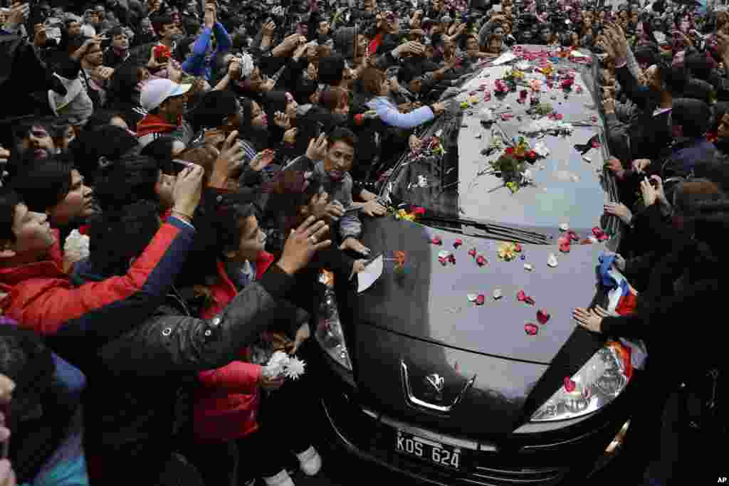 People touch the funeral car transporting the remains of Argentine rock star Gustavo Cerati to a cemetery in Buenos Aires. Cerati died on Thursday, four years after a stroke put him in a coma and ended the career of one of Latin America&#39;s most influential musicians.