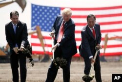 FILE - President Donald Trump, center, along with Wisconsin Gov. Scott Walker, left, and Foxconn Chairman Terry Gou participate in a groundbreaking event for the Foxconn facility in Mt. Pleasant, Wis., June 28, 2018.