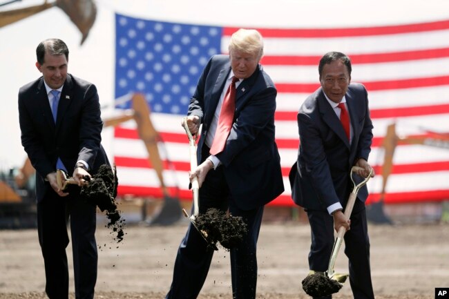 FILE - President Donald Trump, center, along with Wisconsin Gov. Scott Walker, left, and Foxconn Chairman Terry Gou participate in a groundbreaking event for the Foxconn facility in Mt. Pleasant, Wis., June 28, 2018.