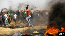 Un manifestant palestinien lance des pierres contre les forces de sécurité israéliennes à Gaza le 6 avril 2018.