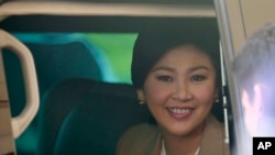 FILE - Prime Minister Yingluck Shinawatra sits in a car as she leaves the Thai Air Force headquarters after a cabinet meeting in Bangkok, Thailand.