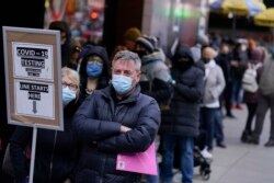 Orang-orang mengantre di tempat pengujian COVID-19 di Times Square, New York City, 13 Desember 2021. Omicron telah mengungguli varian lain dan sekarang menjadi versi dominan virus corona di Amerika Serikat. (Foto: AP)