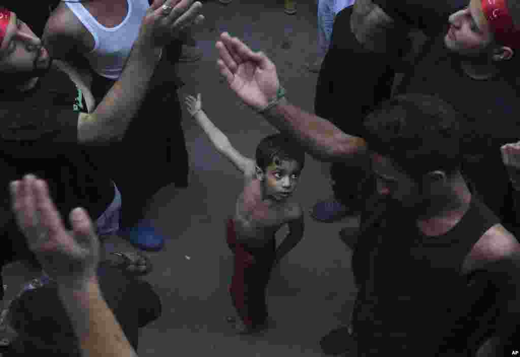 A Shi&#39;ite Muslim child beats his chest next to his father during a procession to mark the end of the 40-day mourning period following the anniversary of the 7th century death of Imam Hussein, the Prophet Muhammad&#39;s grandson and one of Shiite Islam&#39;s most beloved saints, in Lahore, Pakistan.