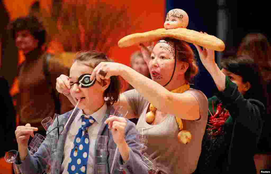 Visitors fix their themed costumes as they attend the Salvador Dali exhibition in Moscow, Russia.