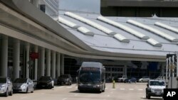 FILE - A bus drives in front of Terminal D at Dallas-Fort Worth International Airport in Grapevine, Texas. Reynobond PE was used in panels on the interior and exterior of the airport's Terminal D facility, which opened in 2005.