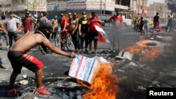 3일 이라크 바그다드에서 반정부 시위 참가자가 타이어에 불을 붙이고 있다. 