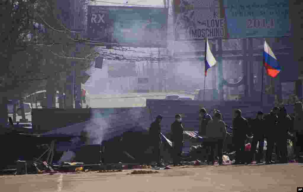 Pro-Russian activists gather behind a barricade with Russian flags in front of the entrance to the regioanl security service office in Luhansk, west of the Russian border, in Ukraine, April 8, 2014.