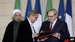 Chief Executive of Suez Environment, Jean-Louis Chaussade (R), Iranian Energy Vice-Minister, Alireza Daemi (L), Iranian President Hassan Rouhani (Background L), and French President Francois Hollande attend a bilateral agreements session in Paris, Jan. 28, 2016.