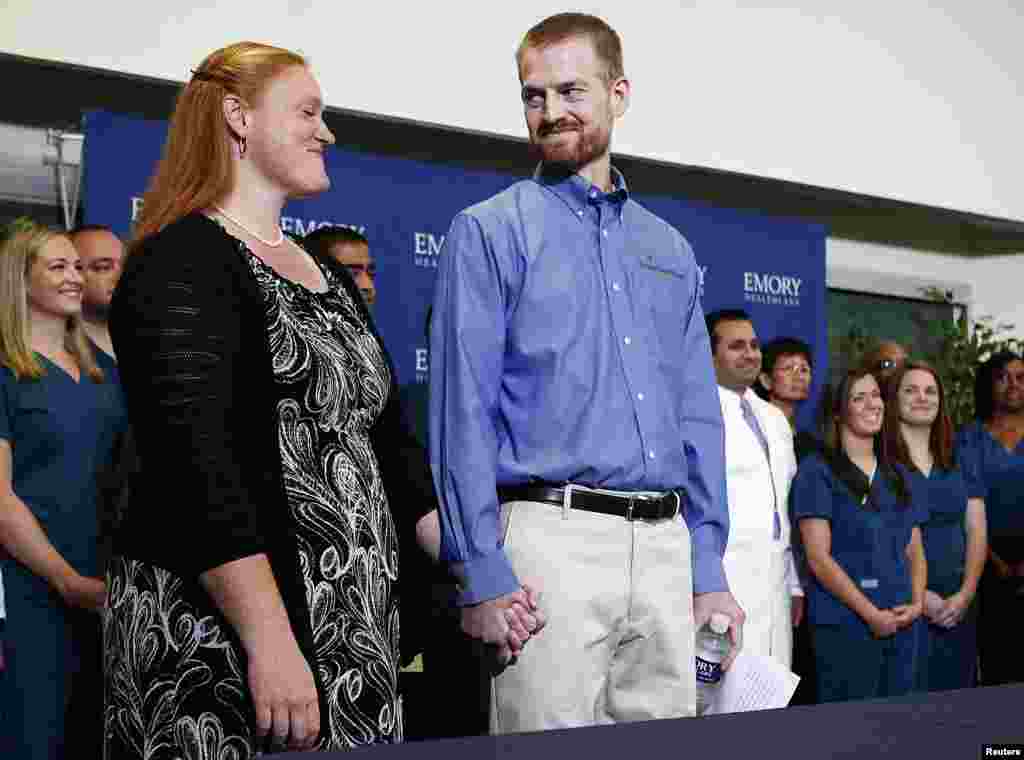 Kevin Brantly, who contracted the deadly virus Ebola, looks at his wife Amber during a press conference at Emory University Hospital, in Atlanta, Georgia, Aug. 21, 2014.