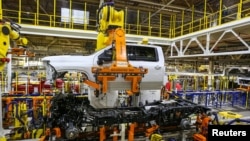 Robots swing a cab and bed into place for a new heavy duty pickup truck on the assembly line where Chevrolet Silverado trucks are being built at General Motors Flint Assembly in Flint, Michigan, Jan. 30, 2019. 