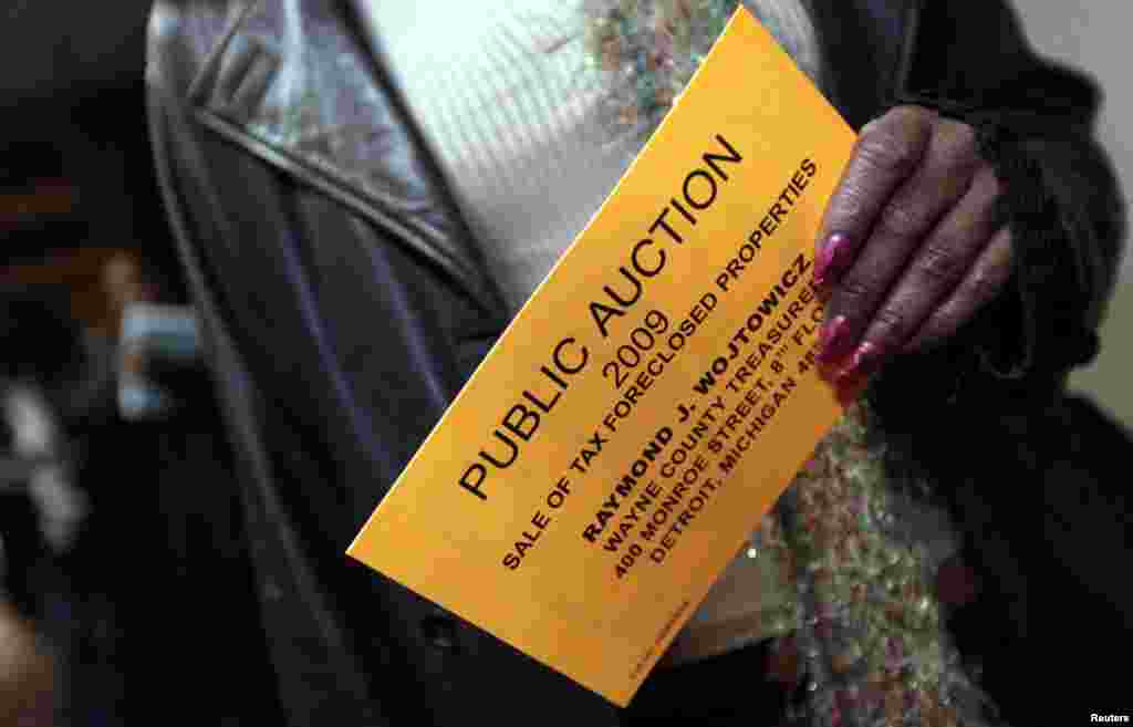 Carla Lyons holds her bidders card as nearly 9,000 foreclosed Detroit area properties are being auctioned off at the International Center Building in Detroit. Picture taken October 19, 2009.