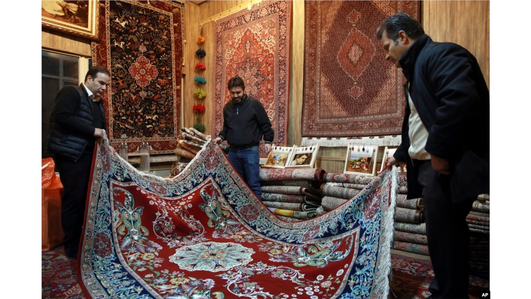 Iranian merchants look at a hand-woven carpet at the Grand Bazaar in Tehran, Feb. 7, 2019.