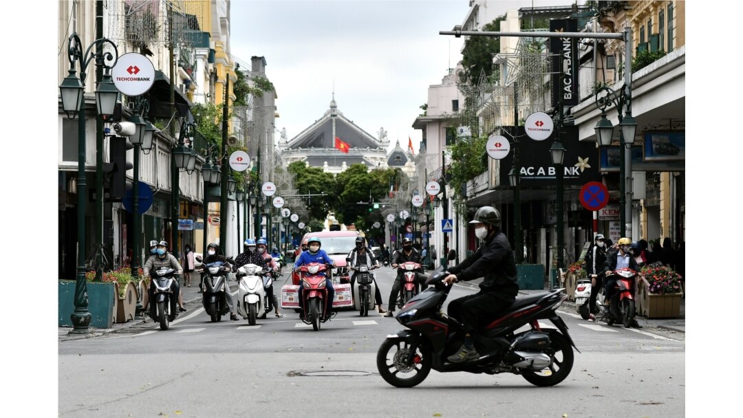 Pengendara motor di sebuah jalan di Hanoi setelah pemerintah Vietnam melonggarkan karantina wilayah untuk mencegah penyebaran virus corona, 23 April 2020.