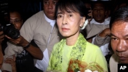Burmese opposition leader Aung San Suu Kyi, center, arrives at Rangoon International airport to leave for United State Sunday, Sept . 16 2012, in Yangon.